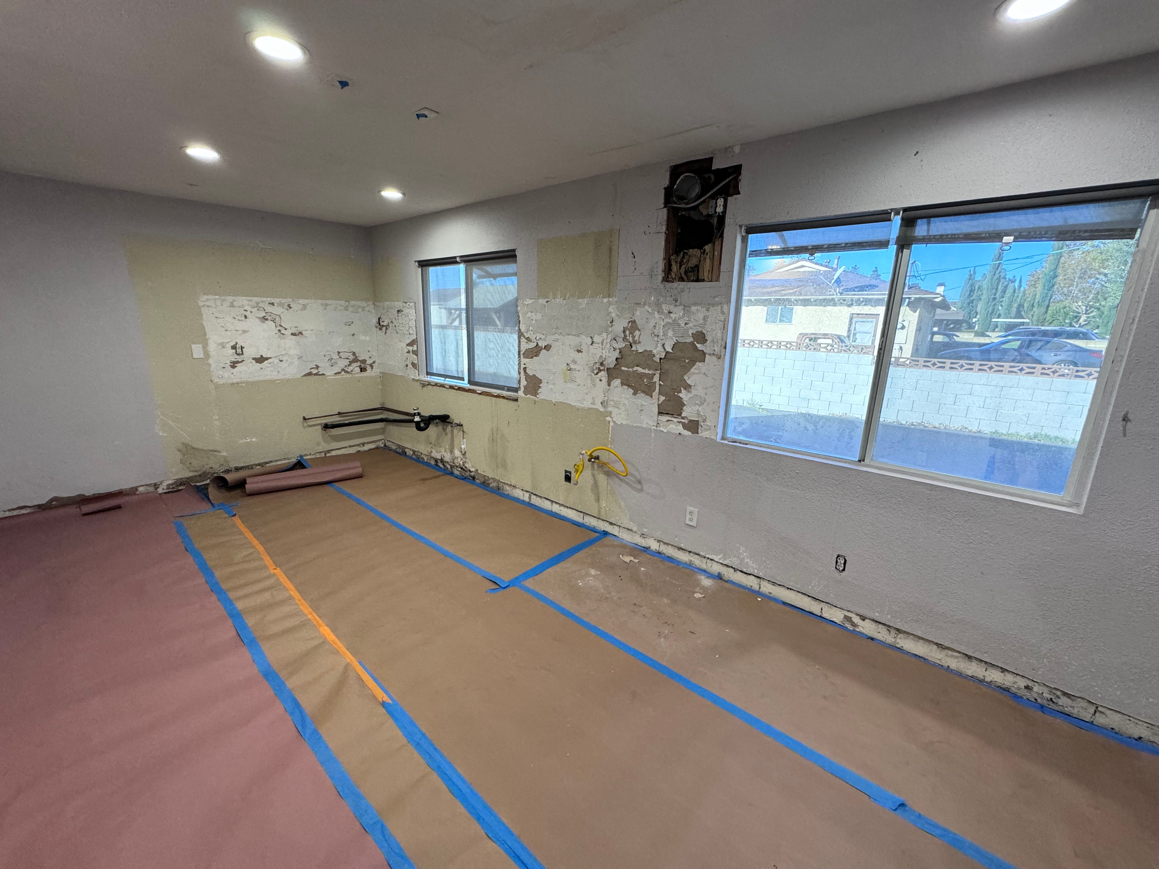 Image of a deconstructed kitchen with cabinets and wall treatments removed. The space is bare, awaiting new furnishings.